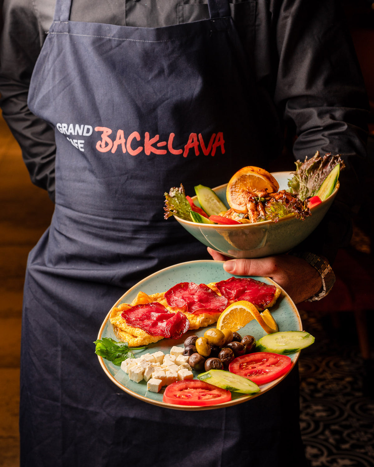 Back-Lava employee serves breakfast plate with fresh ingredients